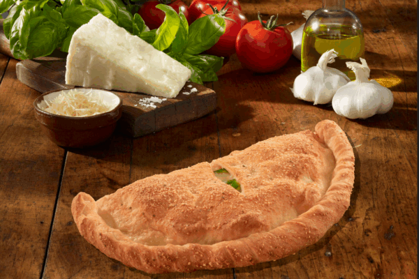 bucks stromboli picture on a board with ingredients of cheese, tomato, peppers, garlic. strombolis can be customized with any ingredients at bucks